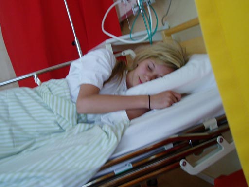 A blond girl sleeping in a bed with green sheets